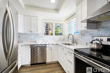 Palm Desert house for rent - A kitchen with white cabinets and a stainless steel refrigerator.