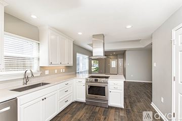 Baton Rouge apartment for rent - A modern kitchen with white cabinets and stainless steel appliances.