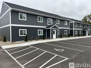 Nicollet apartment for rent - A parking lot with a handicap parking space in front of a grey building.