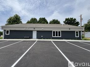 Nicollet apartment for rent - A building with a grey roof and a parking lot in front.