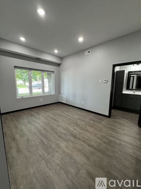 Nicollet apartment for rent - A spacious room with a large window and wooden flooring.