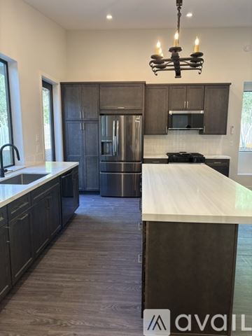 Carmel Valley house for rent - A kitchen with a white counter top and dark wood cabinets.