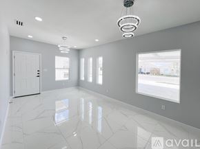 Edinburg apartment for rent - A spacious room with white marble flooring and a large window.