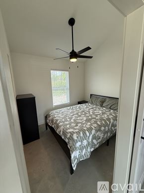 Fayetteville apartment for rent - A bedroom with a bed, a ceiling fan, and a window.