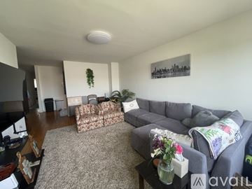 The Bronx apartment for rent - A living room with a grey couch and a coffee table with flowers on it.