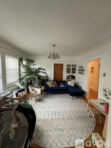 Newton apartment for rent - A living room with a blue sofa and a rug with a pattern.