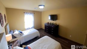 Oklahoma City apartment for rent - A bedroom with two beds and a dresser with a flat screen TV mounted above it.