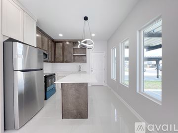 Edinburg apartment for rent - A modern kitchen with a stainless steel refrigerator and a white island.