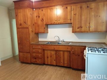 Portland apartment for rent - A kitchen with wooden cabinets and a white stove.