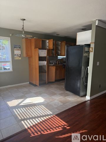 Lynden apartment for rent - A kitchen with a black fridge and wooden cabinets.