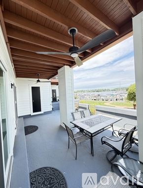 Cornelius condo for rent - A table and chairs are set up on a balcony with a view of a pool and trees.