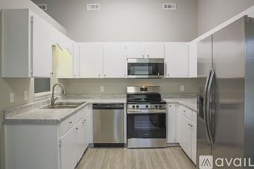 Hinesville house for rent - A modern kitchen with white cabinets and stainless steel appliances.