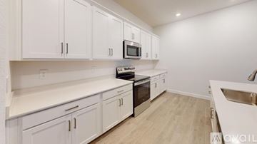 Port Charlotte house for rent - A kitchen with white cabinets and a black stove top oven.