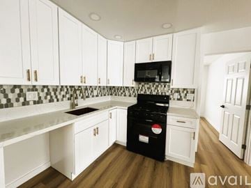 Westminster apartment for rent - A kitchen with white cabinets and a black dishwasher.