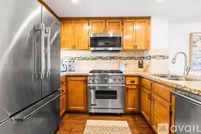Imperial Beach condo for rent - A kitchen with wooden cabinets and a stainless steel refrigerator.