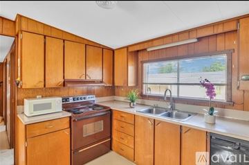 Port Orange apartment for rent - A kitchen with wooden cabinets and a stove top oven.