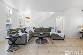 San Diego house for rent - A living room with a grey couch, a black coffee table, and a white wall.