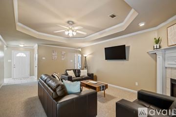Sherwood house for rent - A living room with a brown leather couch and a flat screen TV mounted on the wall.