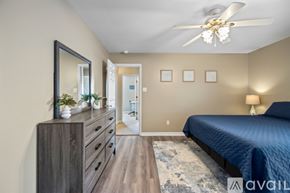 Sherwood house for rent - A bedroom with a blue bed and a ceiling fan.