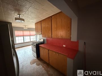 Lawton house for rent - A kitchen with wooden cabinets and a black fridge.