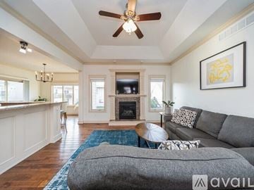 Urbandale house for rent - A living room with a grey couch and a fireplace.