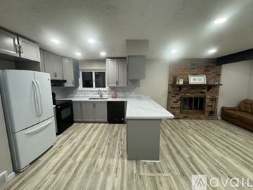 Livonia house for rent - A kitchen with a white refrigerator and wooden flooring.