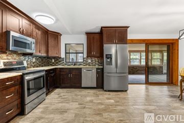Newberry house for rent - A kitchen with wooden cabinets and a stone backsplash.