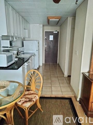 Honolulu condo for rent - A kitchen with a table and chairs in the foreground.