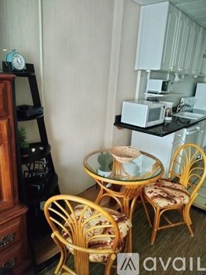 Honolulu condo for rent - A small dining room with a glass table and chairs.
