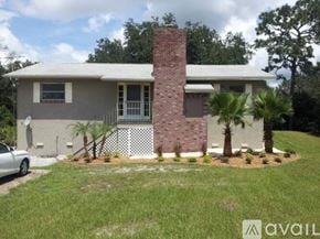 Oviedo apartment for rent - A house with a brick chimney and a white fence.
