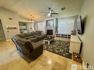 Scottsdale house for rent - A living room with a large couch and a fireplace.