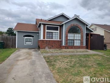 San Antonio house for rent - A house with a grey garage and a brick wall.
