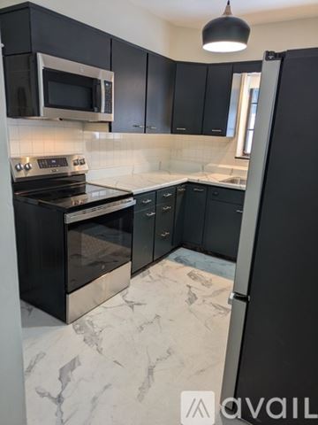 Charleston apartment for rent - A kitchen with black cabinets and a marble floor.