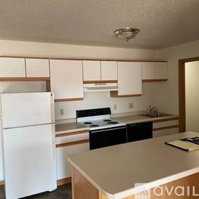 Holmen apartment for rent - A kitchen with white appliances and wooden cabinets.