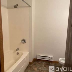 Holmen apartment for rent - A bathroom with a white bathtub and a toilet.