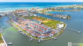Madeira Beach condo for rent - A large outdoor swimming pool surrounded by a tiled floor and lounge chairs.