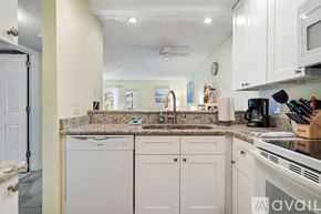 Madeira Beach condo for rent - A bedroom with a bed, a television, and a ceiling fan.