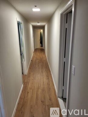 Boston apartment for rent - A long hallway with wood floors and white walls.