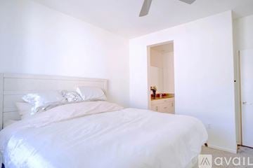 Boston apartment for rent - A bedroom with a large bed and a small dresser with a mirror.
