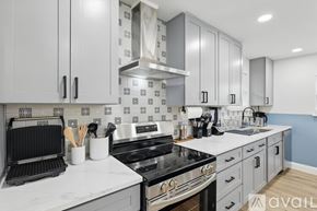 Irving house for rent - A kitchen with a black stove top oven and white cabinets.