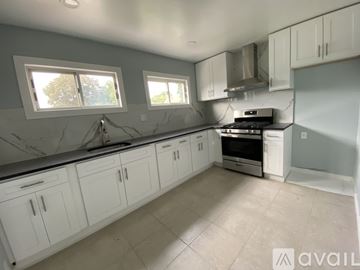 Paterson apartment for rent - A kitchen with white cabinets and a marble countertop.