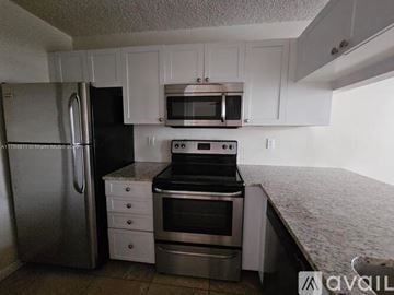 West Palm Beach condo for rent - A kitchen with white cabinets and stainless steel appliances.