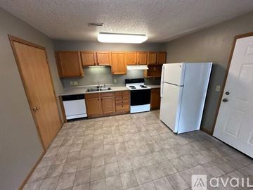 Spencer apartment for rent - A kitchen with white appliances and wooden cabinets.