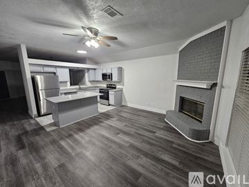 Cedar Hill house for rent - A spacious kitchen and living room with a fireplace and wood flooring.
