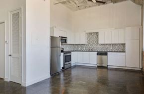Dallas apartment for rent - a kitchen with white cabinets and a stainless steel refrigerator