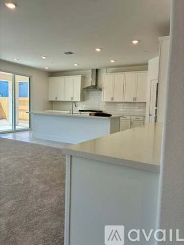 Roseville house for rent - A modern kitchen with white cabinets and a large island.