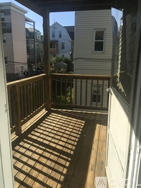 Somerville apartment for rent - A wooden deck with a railing and a window.