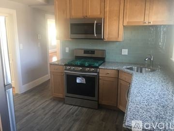 Somerville apartment for rent - A kitchen with wooden cabinets and a stove top oven.