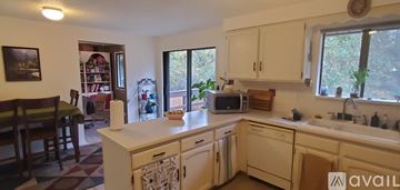 Milwaukie house for rent - A kitchen with white cabinets and appliances.