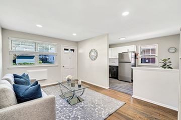 Marlton apartment for rent - A modern living room with a grey sofa and a glass coffee table.